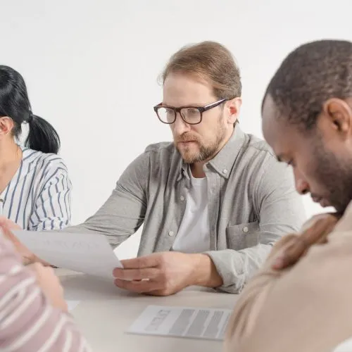 cropped shot of four multiethnic business people working with papers together